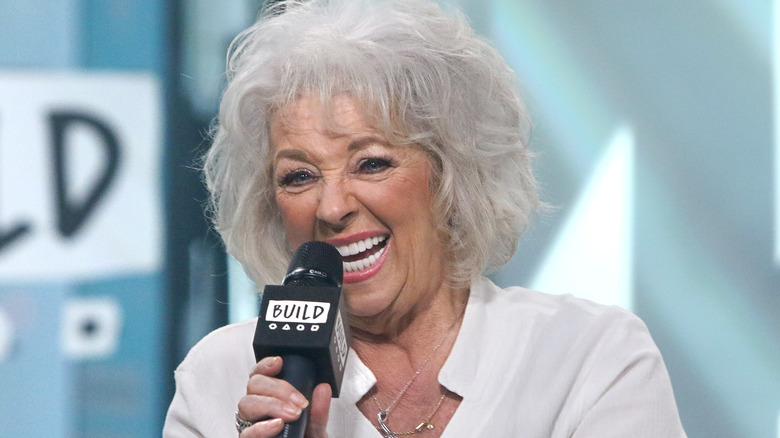 Paula Deen laughing into microphone