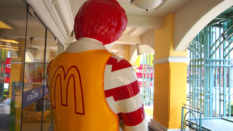 A Ronald McDonald statue photographed from the back.
