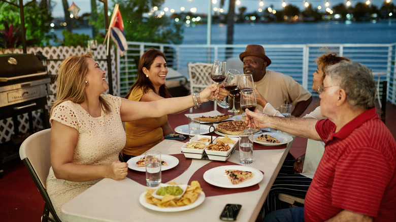 Older friends eating pizza on a Miami waterfront
