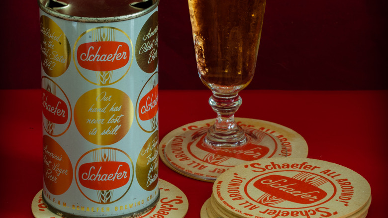 Old-school Schaefer beer﻿ can and glass on coasters.