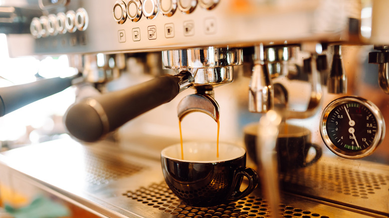 Espresso extracting into a cup.
