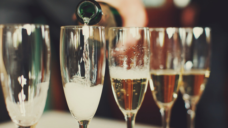 Champagne pouring into multiple glasses