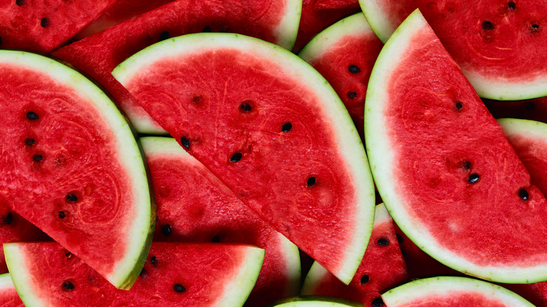 Many slices of seeded watermelon on top of each other