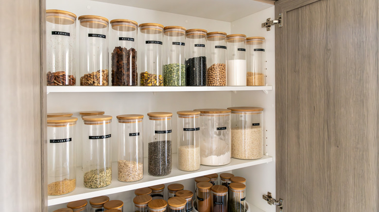 A kitchen pantry with uniform glass jars