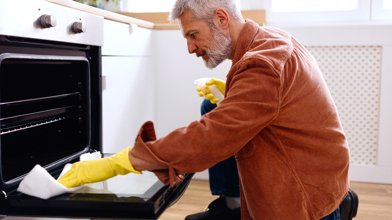 A person cleaning an oven.