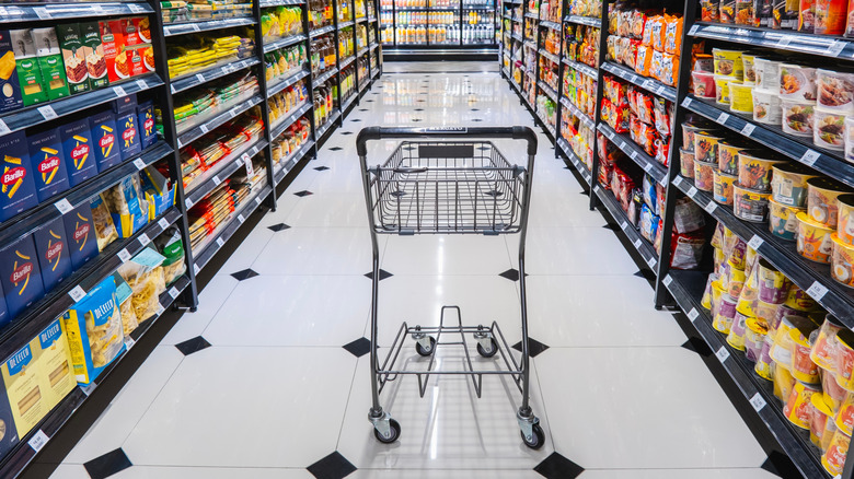 an empty shopping cart in a grocery aisle