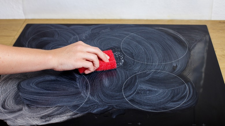 woman cleaning ceramic cooktop