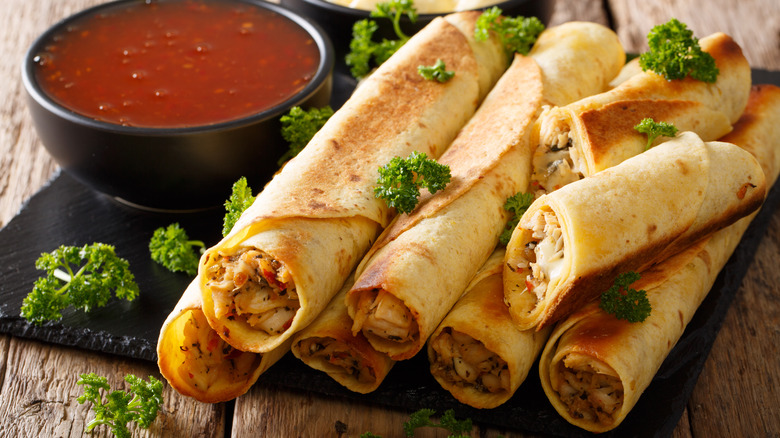 Taquitos and salsa on plate