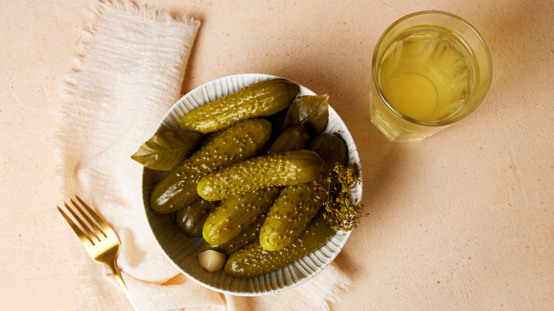 Homemade pickles and a glass of brine.