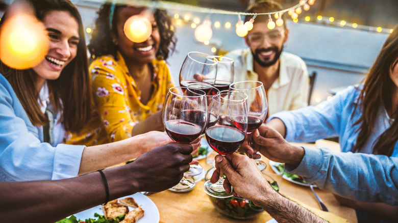 Restaurant customers toast with alcohol at an outdoor patio table
