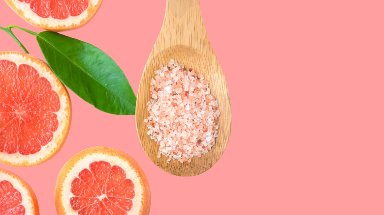 slices of grapefruit and a wooden spoon with himalayan pink salt