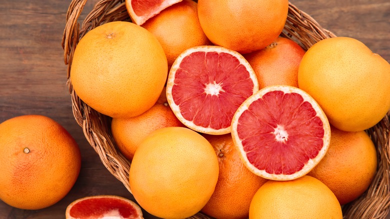 wicker basket of whole grapefruits with one cut in half
