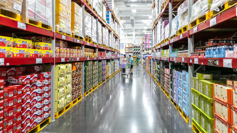 Two shoppers at a Sam's Club look at shelves of merchandise