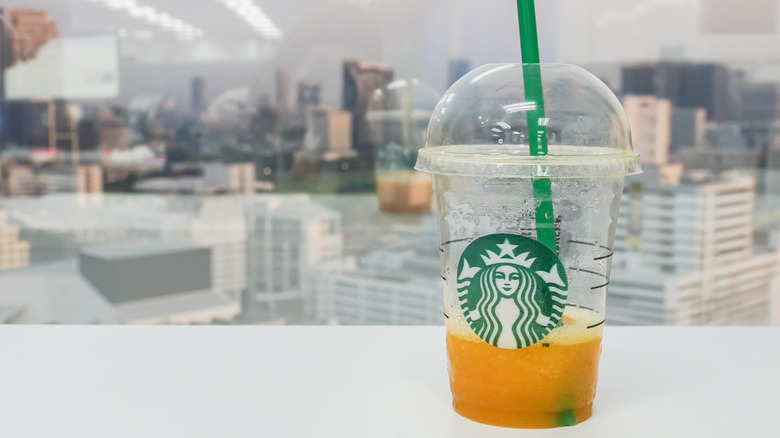 Starbucks mango smoothie in front of cityscape