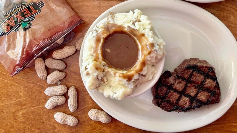Texas Roadhouse mashed potatoes pictured with peanuts and steak.