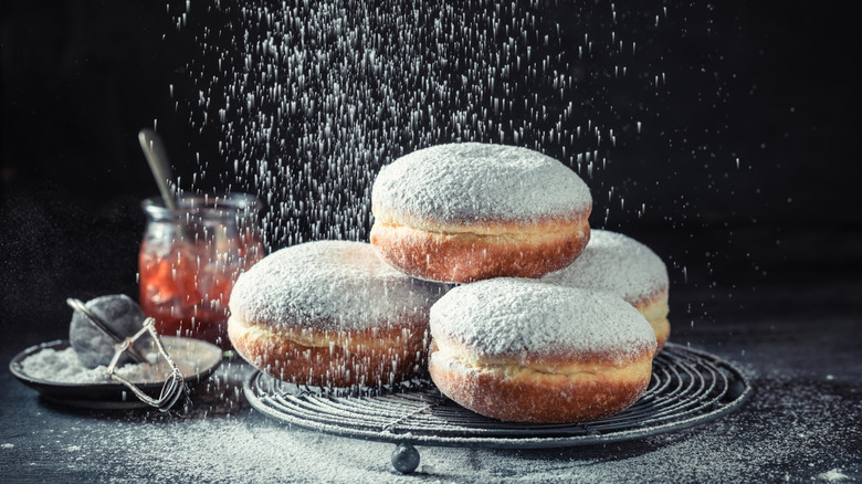 Powdered sugar rains down on filled donuts