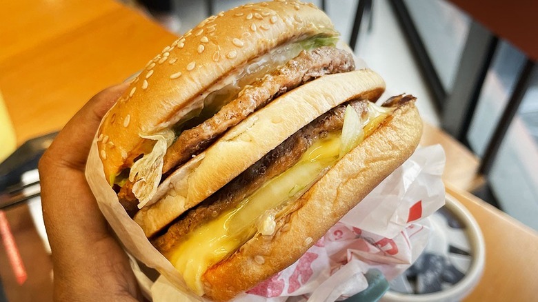 A hand holds a Big King from Burger King.