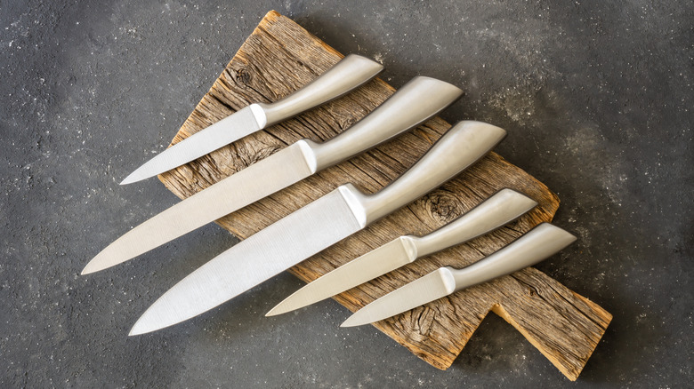 Knives on a wooden cutting board.