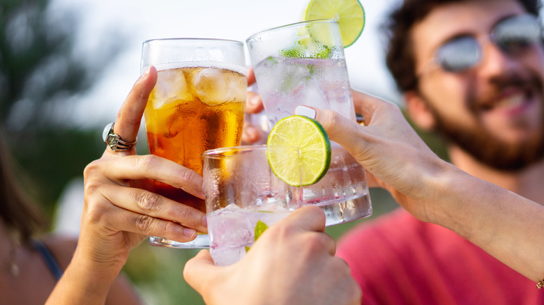 Hands toasting assorted drinks and sodas