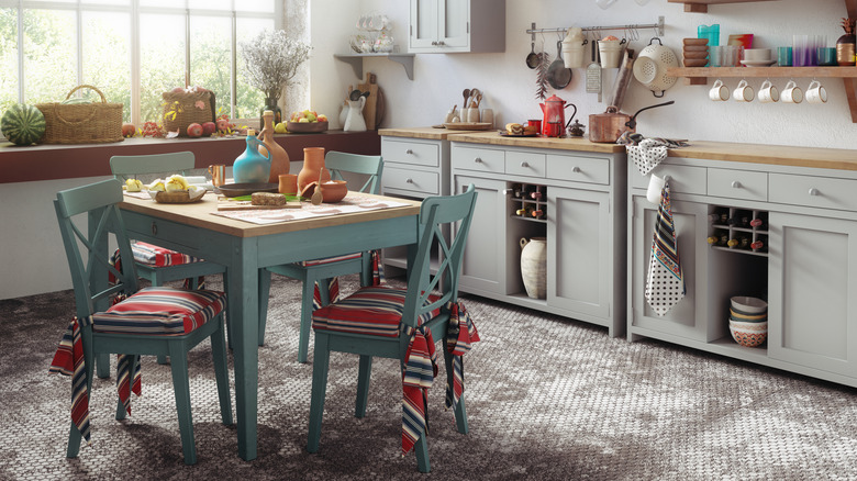A kitchen with colorful cushions, towels, and dishware
