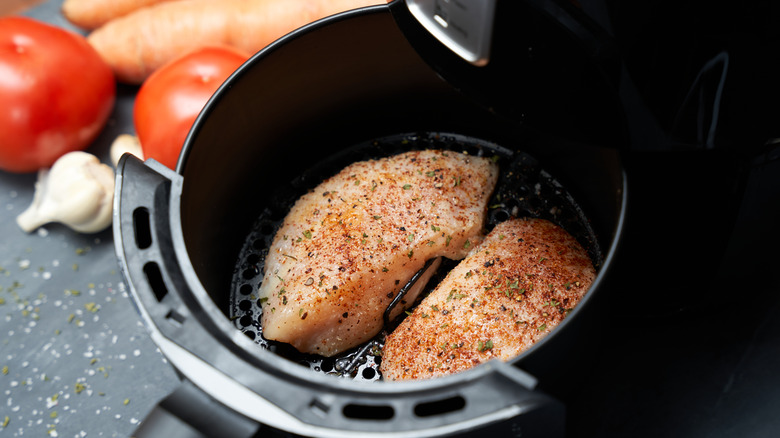 Seasoned chicken breasts in an air fryer