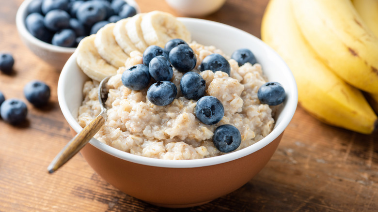 A bowl of oatmeal with blueberries and banana slices