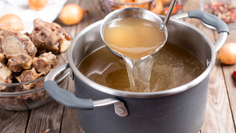 Pot of beef broth with ladle