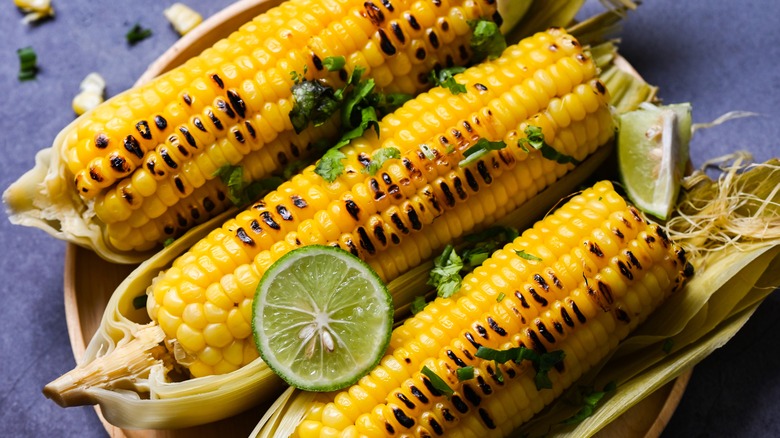 grilled corn sitting in husks