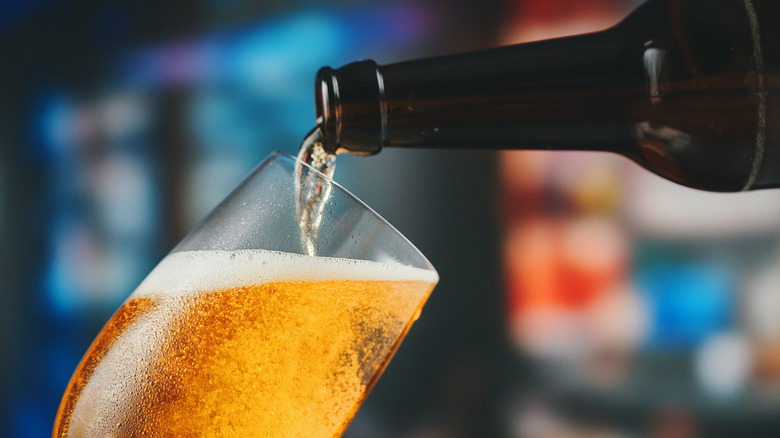 bottle of beer being poured into a glass