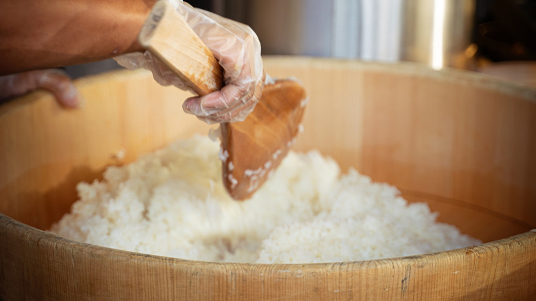 sushi rice stirred in wooden bowl