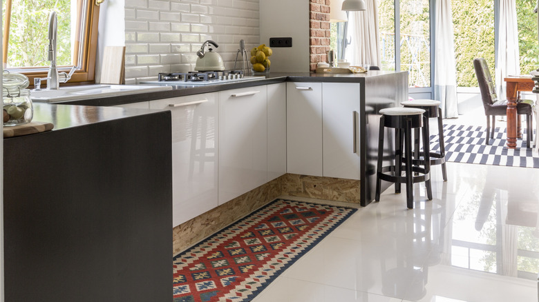 A kitchen with a long rug runner.