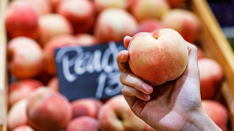 Person holding a peach