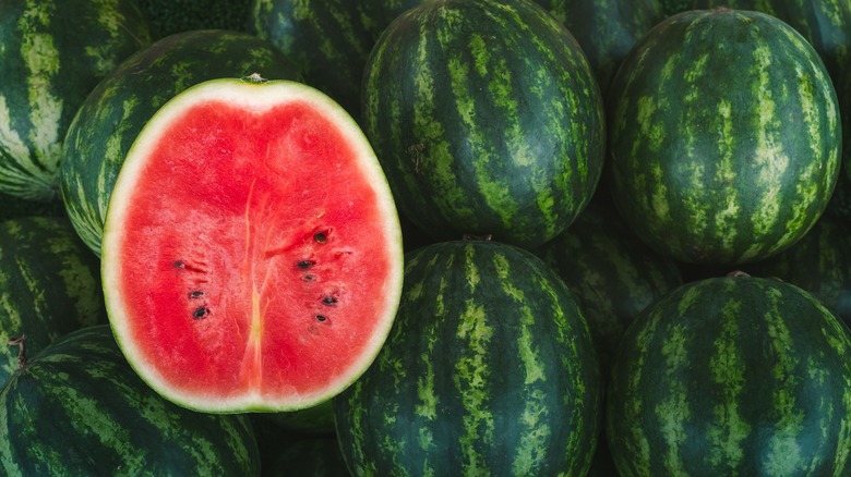 halved watermelon on top of other watermelons