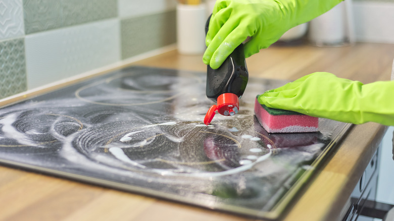 Person cleaning glass stove
