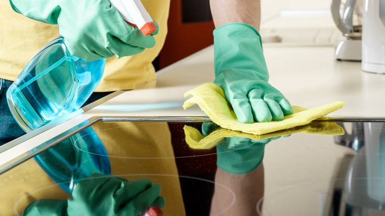 Person cleaning glass stove 