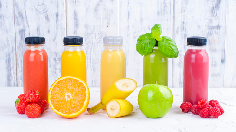 array of cold-pressed juices next to fruits