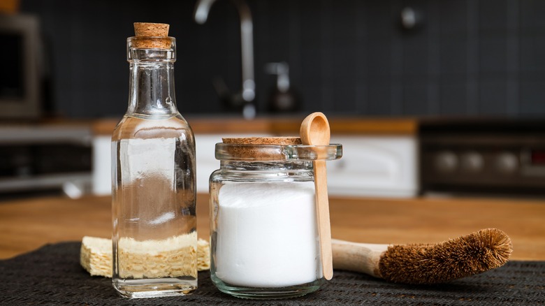 Glass bottles of baking soda and brush