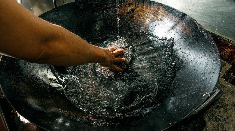 Filling wok with water to clean