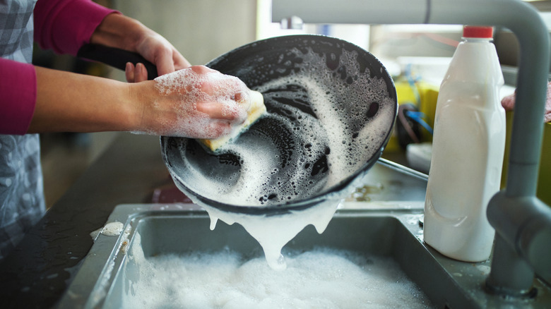 Someone washes a pan.