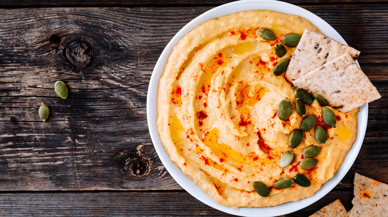 carrot hummus with crackers and pepitas
