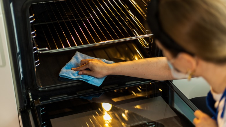 Woman cleaning inside of oven