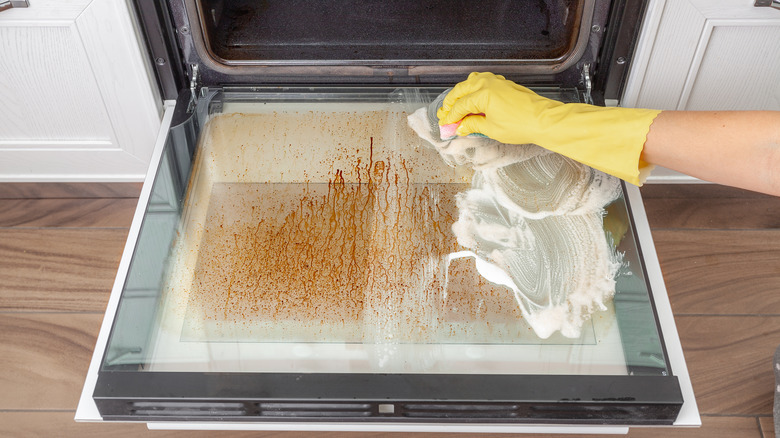 Person wiping the inside of an oven
