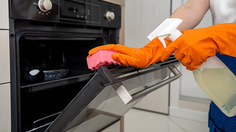 Person cleaning an oven