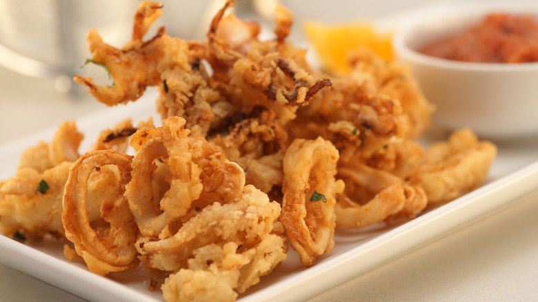 fried calamari on a platter with tomato sauce