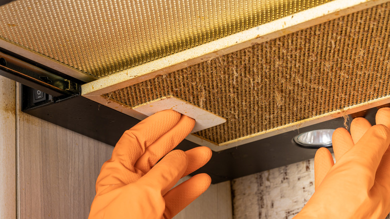 hands removing grease filter