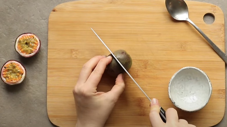 Slicing passion fruit on cutting board 