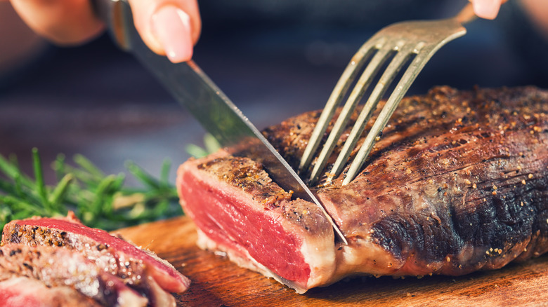 Woman cutting steak against the grain