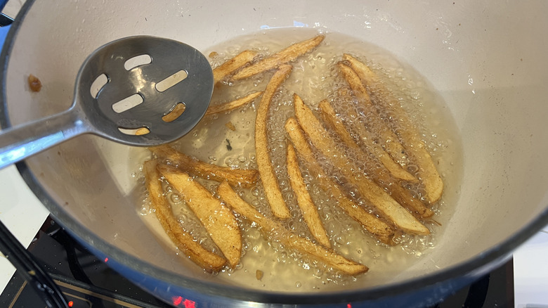 Deep frying homemade french fries in oil