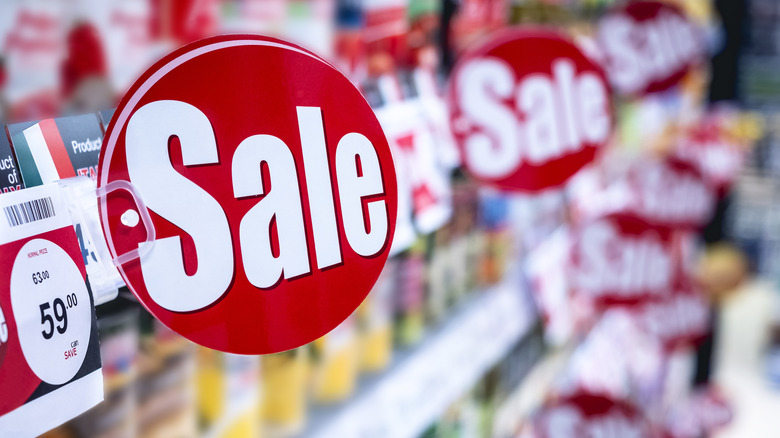 sale signs on grocery store shelf