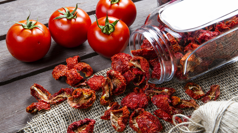 Fresh and dehydrated tomatoes on wood table